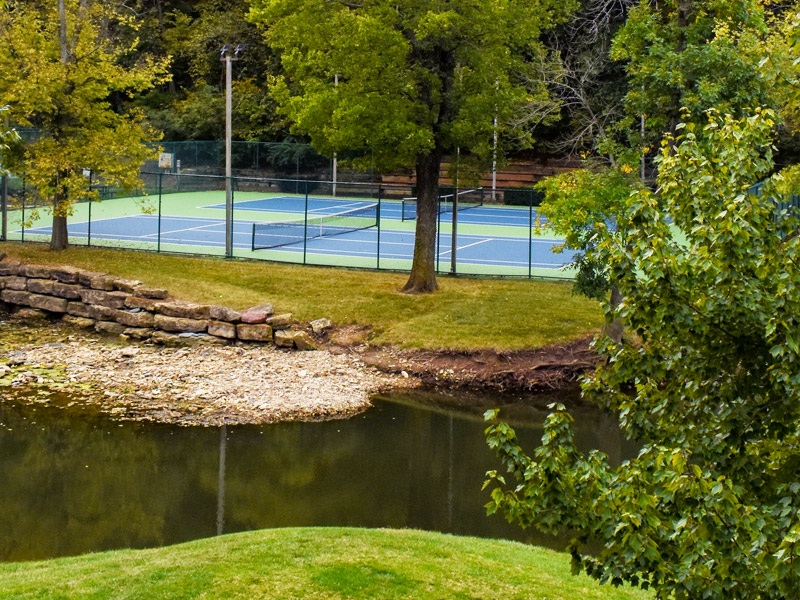 tennis courts with creek in the foreground